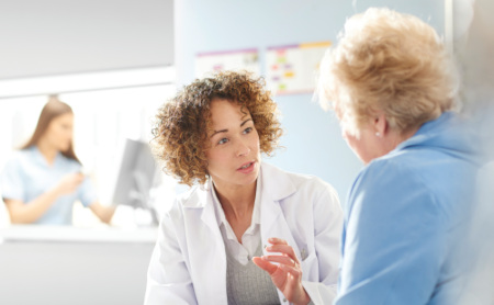 A female doctor discusses a patient's hearing care options after the hearing test is complete